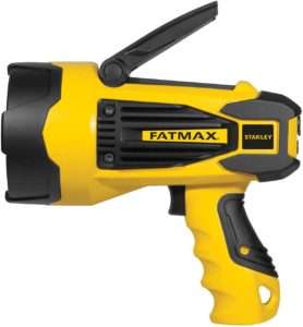 A durable black and yellow portable spotlight with a comfortable grip, emitting a powerful beam to illuminate a dense forest trail during nighttime outdoor activities.