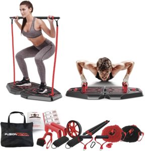 Two individuals demonstrating exercises on a base platform with resistance bands, handles, and attachments. Additional components include a carrying bag, exercise guide, resistance bands, handles, an abdominal wheel, and other accessories.