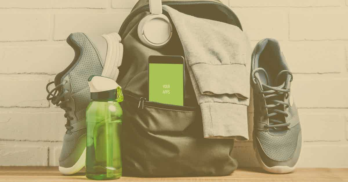 A collection of gym items, including gray athletic shoes, a green water bottle, a gray backpack with a gray hoodie draped over it, a smartphone partially visible in the backpack’s front pocket displaying the text "YOUR APP," and white headphones hanging from the backpack.