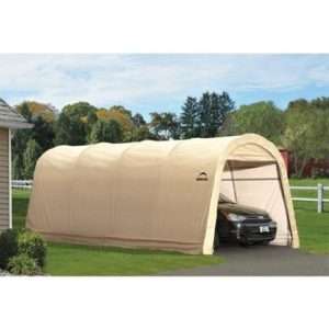 A beige portable garage tent with a peaked roof, providing spacious shelter for a parked car in a suburban driveway surrounded by green trees and a white fence.