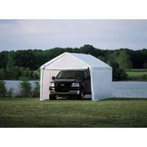 A spacious white portable garage tent near a scenic lake, shielding a parked black truck from rain and sunlight. Its sturdy frame and weather-resistant fabric ensure reliable protection for vehicles.