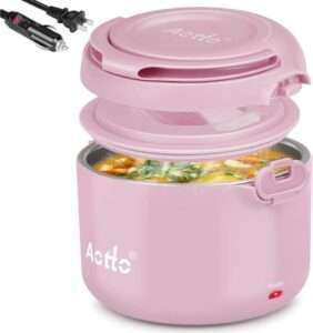 A pink portable food warmer with a detachable lid, showing a meal inside. The device has a power indicator light and comes with both a standard plug and a car adapter.